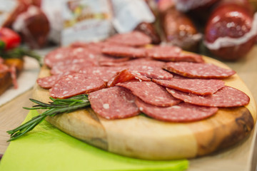 Sandwich with sliced sausage and herbs on kitchen
