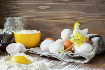 Fresh chicken eggs kitchen wooden table for making a festive Easter cake, dark background