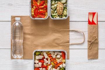 Healthy food take away in boxes, top view at wood