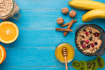Breakfast with oatmeal, berries, honey, fruits and nuts. Space for text.
