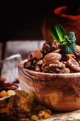 Raisins, dried apricots and assorted nut in a wooden bowl, selective focus