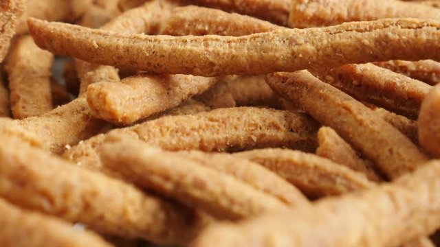 Grissini snack made of dough with chilli slow tilt 4K 2160p 30fps UltraHD footage - Close-up of tasty integral breadsticks fried in oil 3840X2160 UHD tilting video 