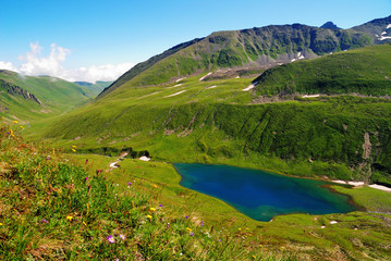 Naklejka na ściany i meble Mountain Lake in the Caucasus summer. Blue sky with white clouds.