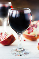 Organic pomegranate wine on white wooden table.