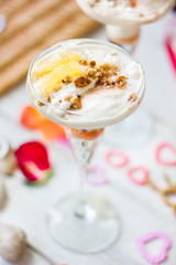 Ice cream dessert on table with hearts, ribbons and cloves.