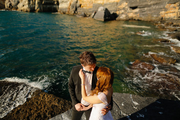 Groom and bride on the rocks by the sea