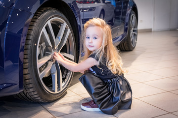 Fototapeta na wymiar Small girl in car exhibition room