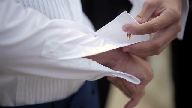 Man wearing golden cufflinks in white shirt