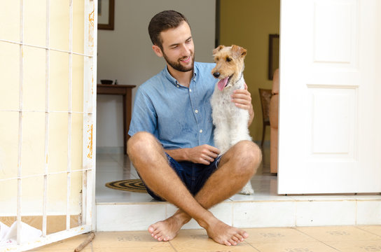 A Man And A Dog. Man Sitting On The Porch With His Pet.