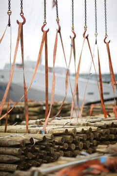 Chains and hooks hoist with slings for loading timber in the port