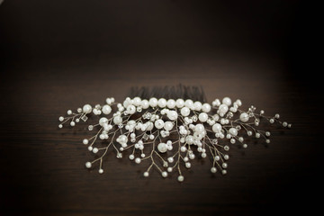 wedding decoration for hair comb in white beads and beaded close-up black brown wooden background copyspace