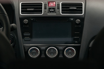 Display, climate control and air vents in the car.