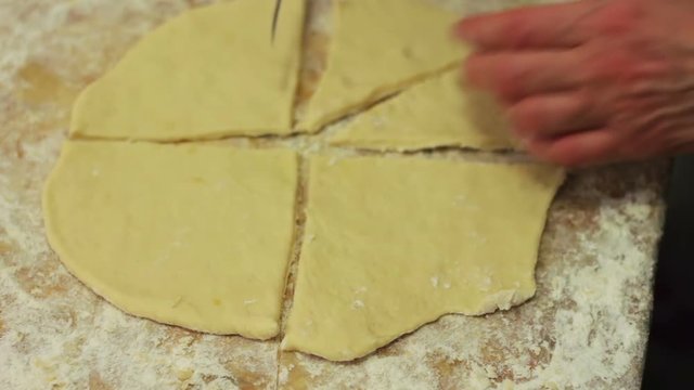 Woman cutting dough with a knife