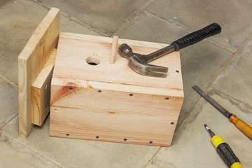 Ready birdhouse and tool lying on the floor  in the workshop