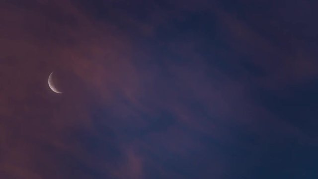 Crescent moon and clouds flowing at dawn

