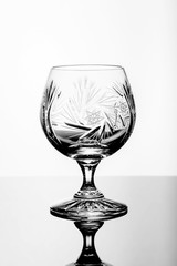 Crystal glass on a glass table, white background