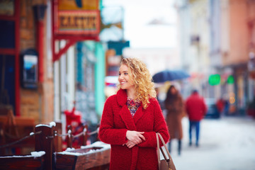 beautiful happy woman walking on city street in winter