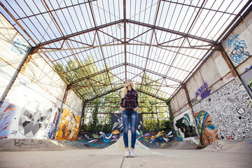 hipster teenage woman standing on a skate park