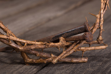 Closeup of Crown of Thorns and Nails on a Wooden Surface