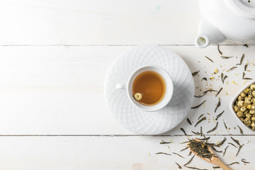 Fototapeta na wymiar Hot tea with tea pot on white wood background