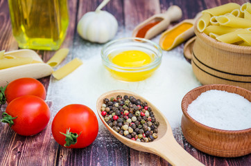 Still life with pasta ingredients and wooden accessories