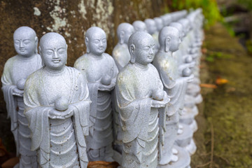 Rows of similar Japanese Jizo sculptures in Kamakura, Japan