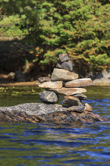 Inukshuk standing on a rock on Sunbeam Lake in Algonquin Provincial Park, Ontario, Canada
