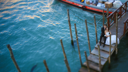 Fototapeta premium Groom and bride on a deck near water