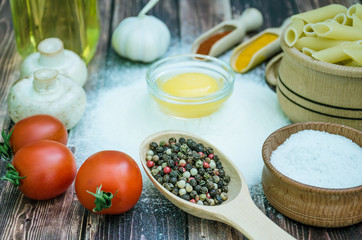 Still life with pasta ingredients and wooden accessories