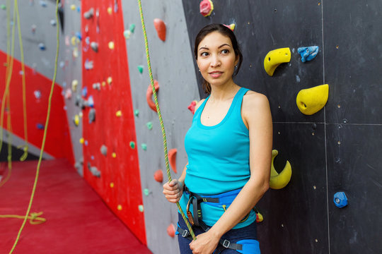 Young woman exercises on indoor rock climber