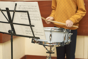 Young boy playing drum using notes