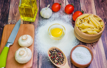 Still life with pasta ingredients and wooden accessories