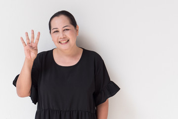 happy, smiling woman pointing up four finger counting hand sign, middle age model.