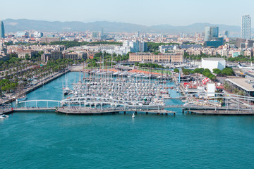 Obraz premium Port of Barcelona. Harbor with luxury yachts parked in the city center against the backdrop of urban development