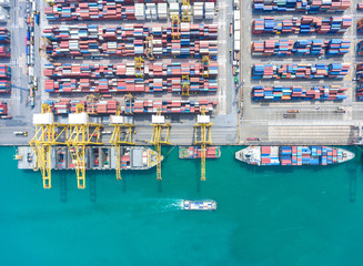 Fototapeta na wymiar container ship in import export and business logistic.By crane , Trade Port , Shipping.Tugboat assisting cargo to harbor.Aerial view.
