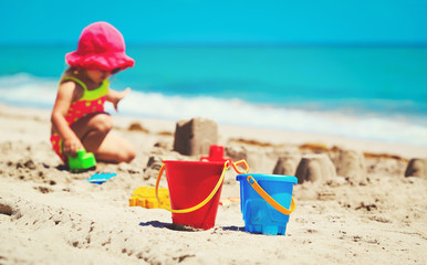 kids toys and little girl playing on the beach