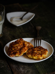 pancakes with cottage cheese and corn (cheesecakes) with a glass of milk on the table