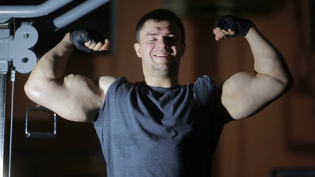 bodybuilder posing in front of a mirror in the gym. posing