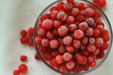 Berries cranberries, frosted, glass plate in front of a white linen cloth, close-up , top view,  selective focus
