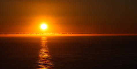 Fototapeta na wymiar Sun setting over ocean