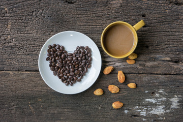 Coffee cup espresso tree in one and coffee beans heart shape background on a wooden table , top view