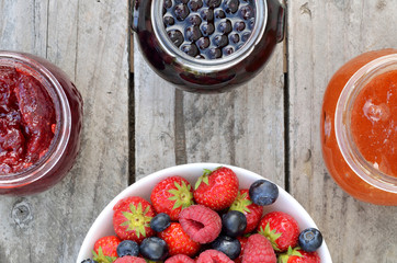 Bowl with blueberries, strawberries, raspberries and jams
