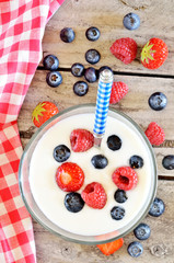 Obraz na płótnie Canvas White yogurt in a bowl with blueberries, raspberries and strawberries