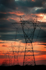 Power Lines for Electricity Metal Towers and Sunset
