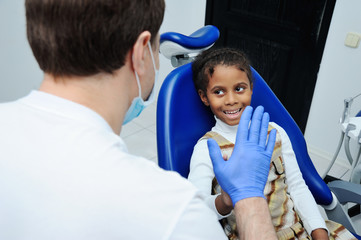 Obraz premium girl with black skin in the dental chair