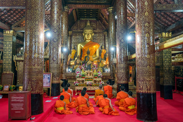 Fototapeta premium Praying Monks at Wat Xieng Thong luang prabang