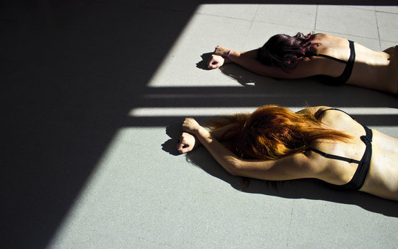 Women on the floor with hands tied