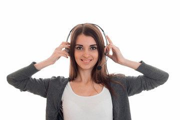 young charming brunette business woman with headphones and microphone looking at the camera and smiling isolated on white background