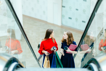 sale, consumerism and people concept -  beautiful  young women with shopping bags rising on...