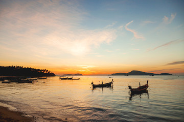 Fototapeta na wymiar Sunrise on Phuket island, Thailand. Seascape with fishers boats. Early morning on Rawai beach.